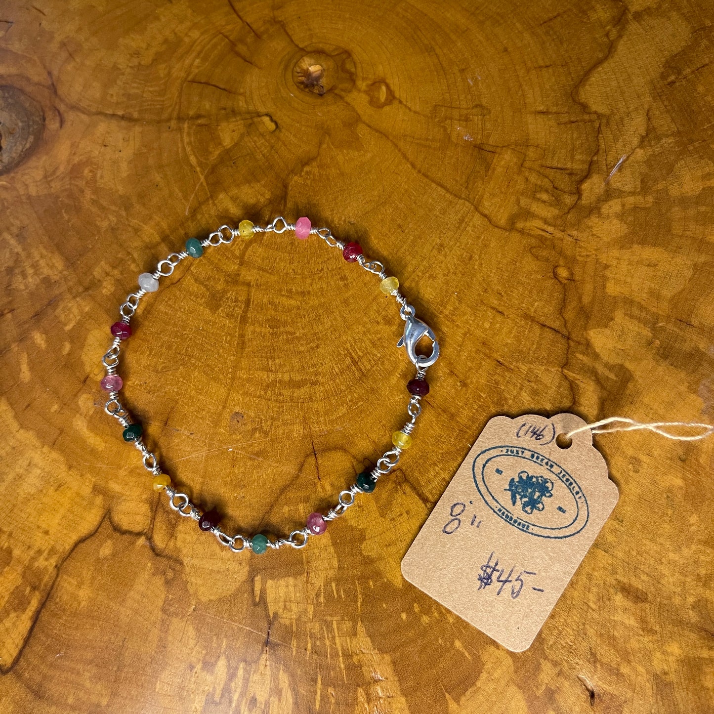 Multi Colored Jade on Sterling Silver wire with Sterling Silver Lobster clasp, 8" on wood