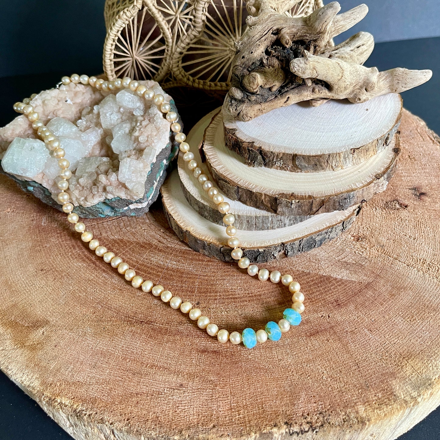 Pink pearl and Blue Chalcedony accented necklace on wood with crystal