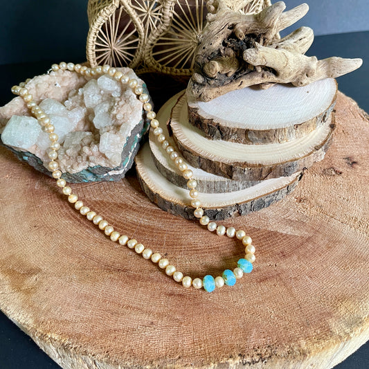 Pink pearl and Blue Chalcedony accented necklace on wood with crystal