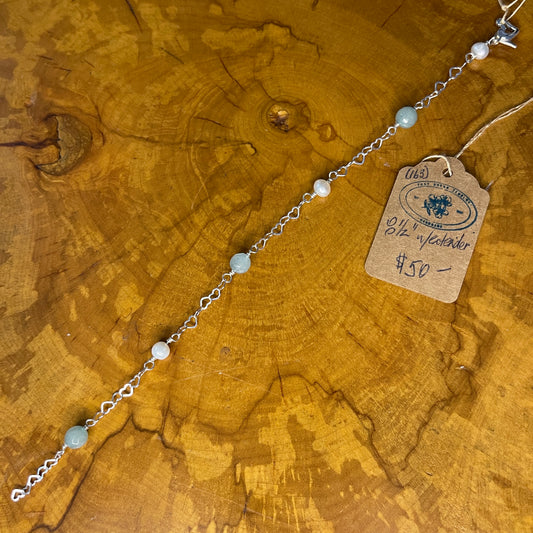 Amazonite and White Freshwater pearls on Sterling Silver Heart Chain, 8" with 1/2 " Sterling Silver heart chain extender on a wooden surface